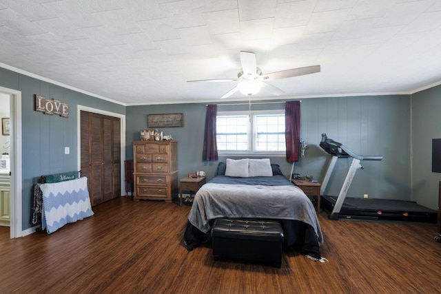 bedroom with ornamental molding, ceiling fan, dark wood-type flooring, and a closet