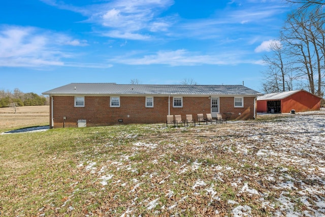 rear view of house featuring a yard and brick siding