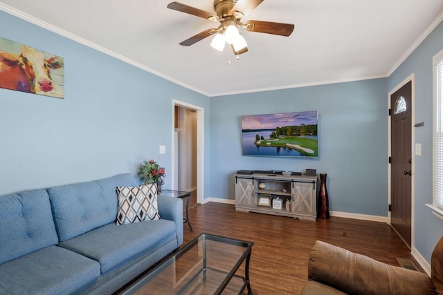 living area with ornamental molding, dark wood finished floors, baseboards, and a ceiling fan