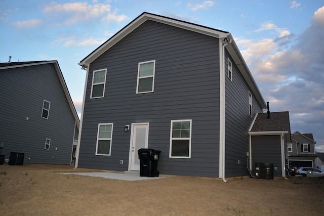 back of house with a lawn and central AC unit