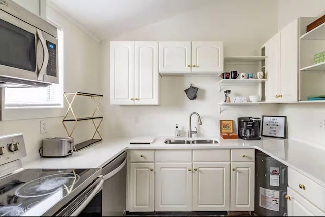 kitchen featuring stainless steel appliances, a sink, white cabinetry, light countertops, and open shelves