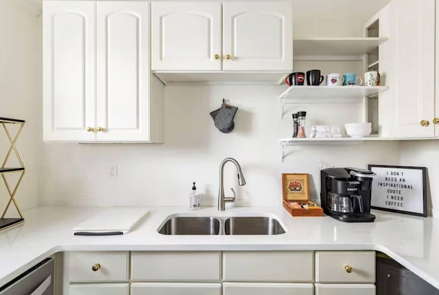 kitchen featuring light countertops, open shelves, a sink, and white cabinetry