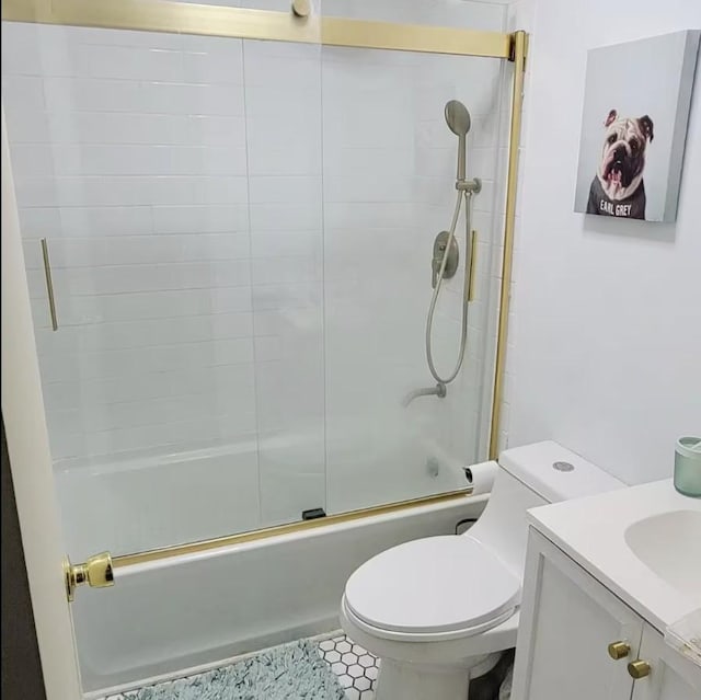 bathroom with toilet, tile patterned flooring, enclosed tub / shower combo, and vanity