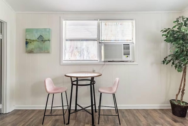 dining area featuring ornamental molding, cooling unit, wood finished floors, and baseboards