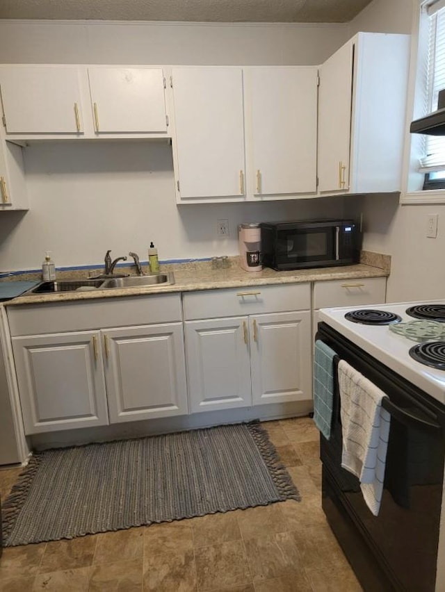 kitchen featuring black microwave, white cabinetry, a sink, and range with electric stovetop