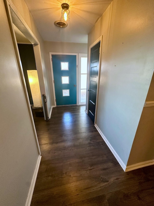 doorway to outside featuring dark wood-style floors, visible vents, and baseboards