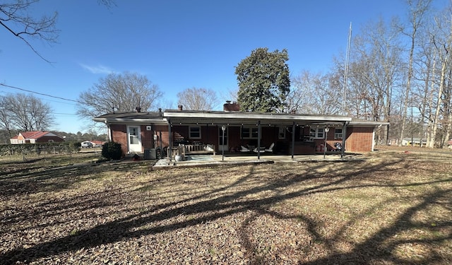 back of house featuring a patio and brick siding