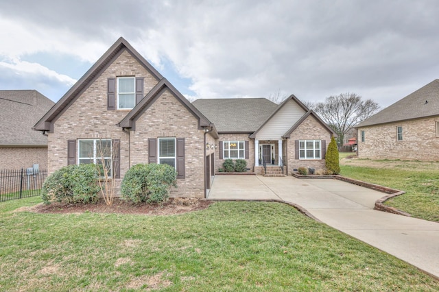 craftsman-style home featuring brick siding, roof with shingles, a front yard, and fence