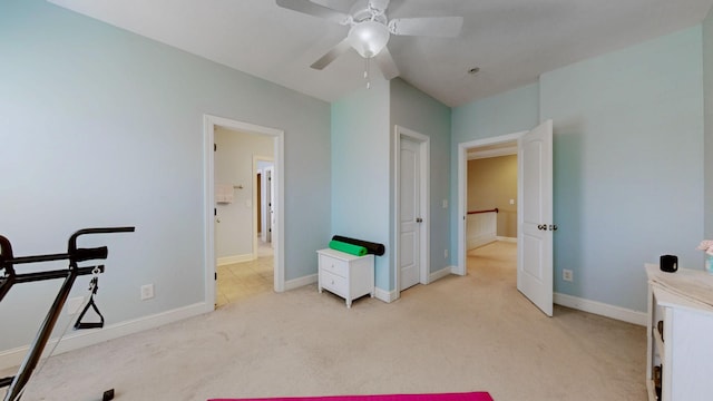 exercise area with light carpet, baseboards, and a ceiling fan