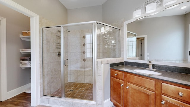 full bathroom featuring baseboards, a shower stall, vanity, and wood finished floors