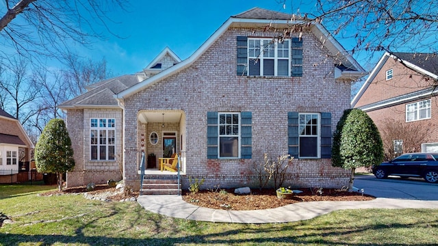 traditional-style home featuring a front lawn and brick siding