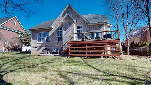 rear view of property with stairway, fence, a deck, a yard, and brick siding