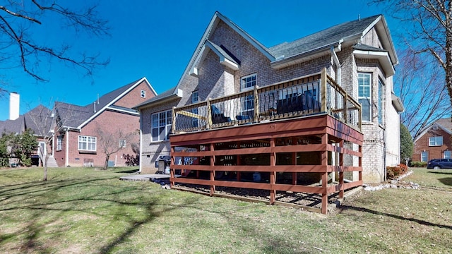 back of house with brick siding, a lawn, and a wooden deck