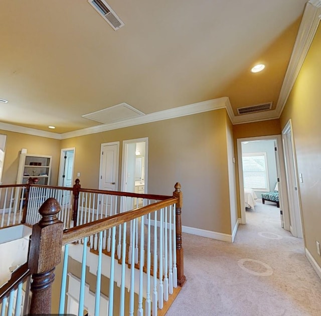 hallway with attic access, visible vents, baseboards, and an upstairs landing