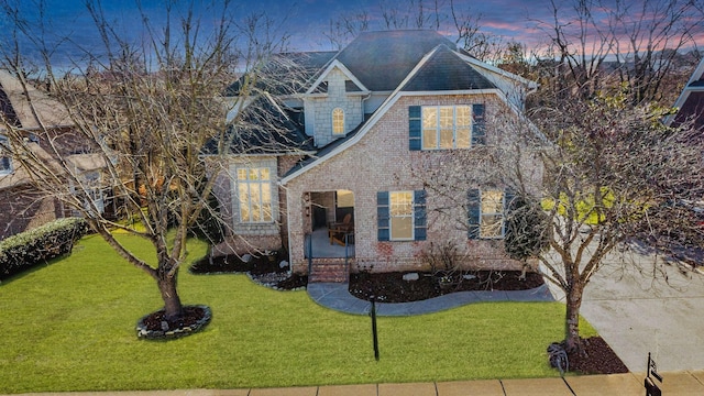 view of front of property with brick siding and a front lawn