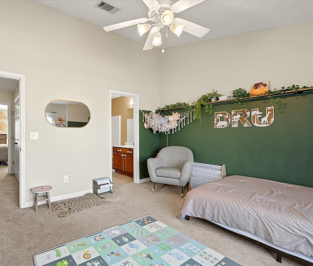 bedroom with light carpet, ensuite bathroom, visible vents, and baseboards