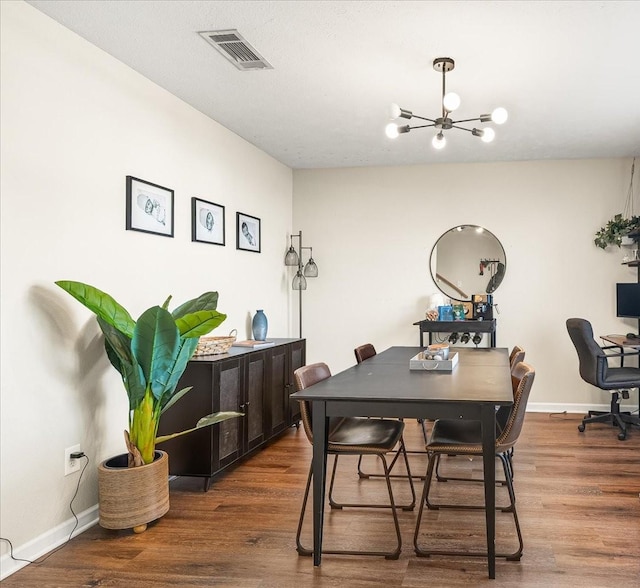 dining area featuring an inviting chandelier, baseboards, visible vents, and wood finished floors