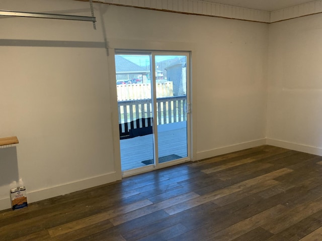 spare room featuring dark wood finished floors and baseboards