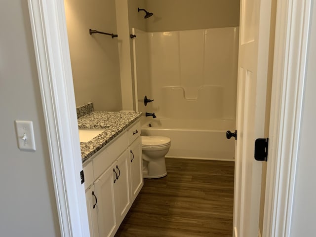 full bathroom featuring toilet, bathing tub / shower combination, wood finished floors, and vanity