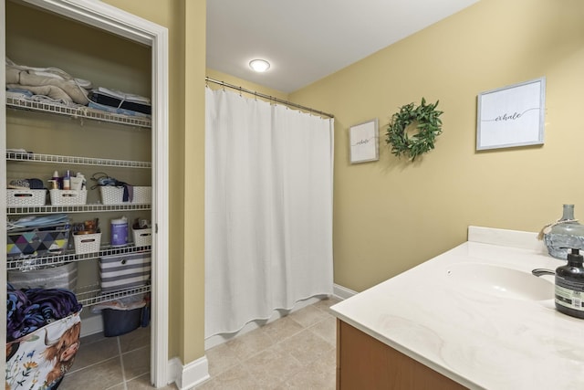 full bath featuring tile patterned flooring, vanity, and baseboards