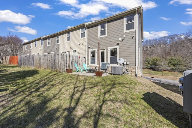 rear view of property featuring a yard, a patio area, fence, and central AC unit