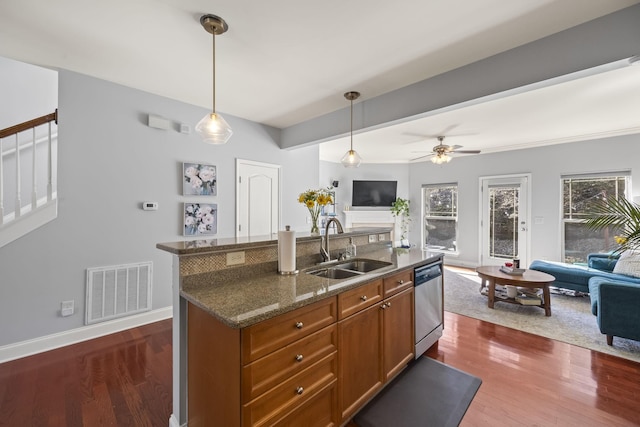 kitchen with open floor plan, hanging light fixtures, stainless steel dishwasher, and a sink