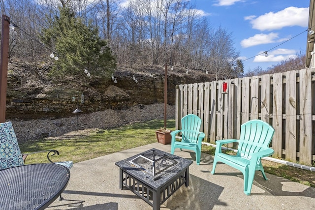 view of patio with a fire pit and fence