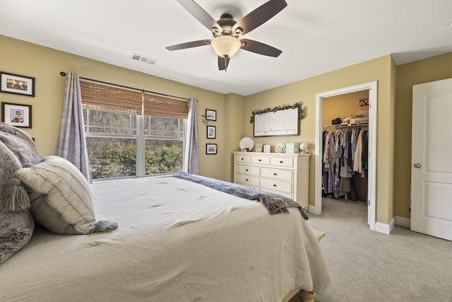 bedroom featuring baseboards, visible vents, light colored carpet, a spacious closet, and a closet