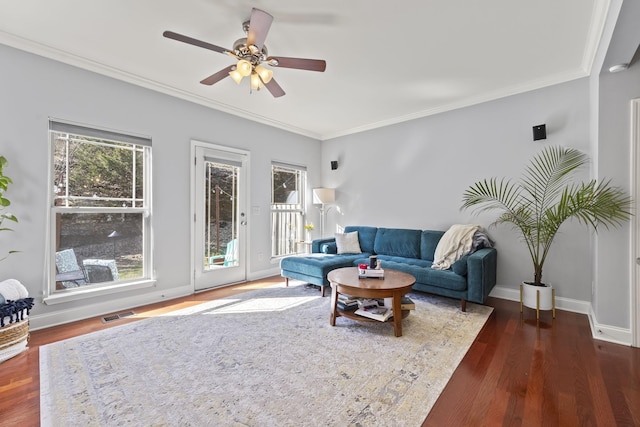 living room with dark wood-style floors, plenty of natural light, baseboards, and crown molding