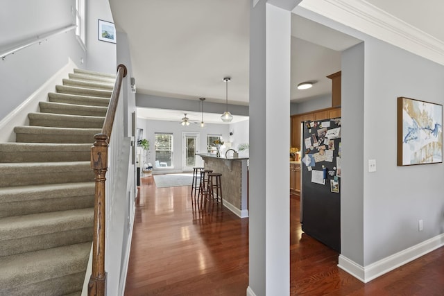 stairs with ceiling fan, wood finished floors, and baseboards