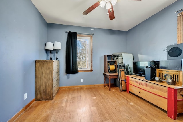 office space featuring light wood-style floors, baseboards, and a ceiling fan