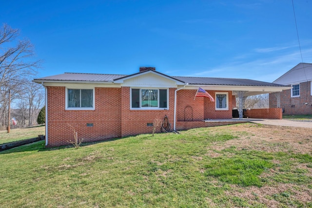 view of front of property featuring metal roof, brick siding, driveway, crawl space, and a front yard