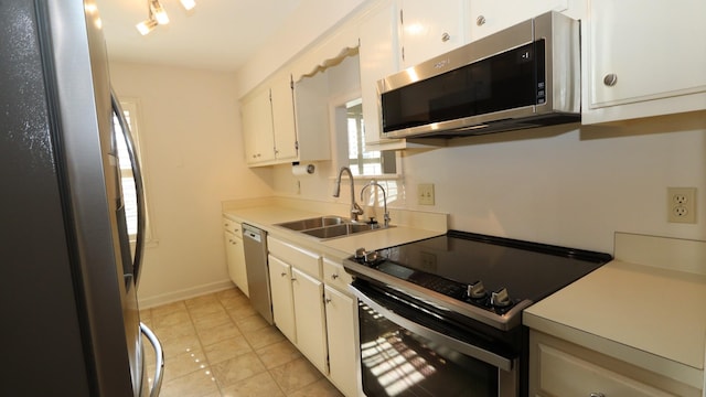 kitchen featuring a sink, white cabinetry, baseboards, light countertops, and appliances with stainless steel finishes