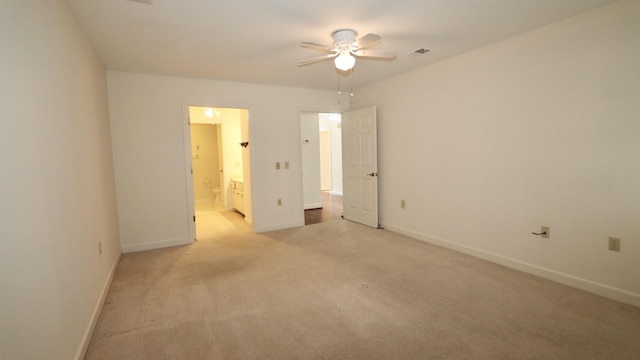 unfurnished bedroom featuring light carpet, baseboards, visible vents, a ceiling fan, and connected bathroom