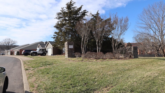 exterior space featuring aphalt driveway, a yard, and a garage