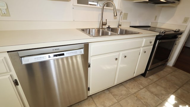 kitchen with stainless steel appliances, white cabinets, light countertops, and a sink