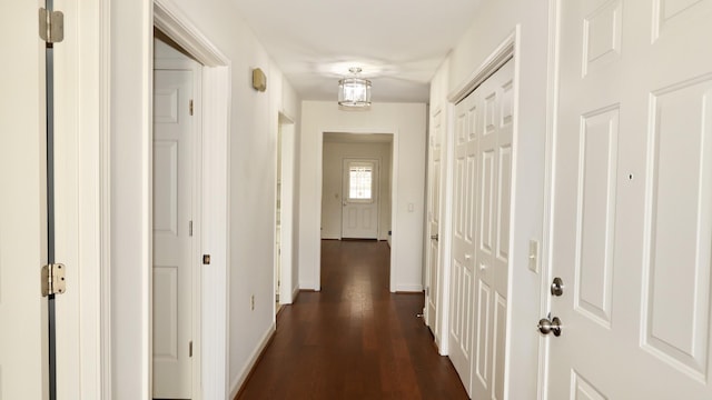 hallway with baseboards and dark wood-type flooring