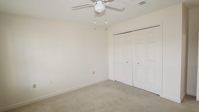 unfurnished bedroom with a closet, visible vents, light carpet, and baseboards