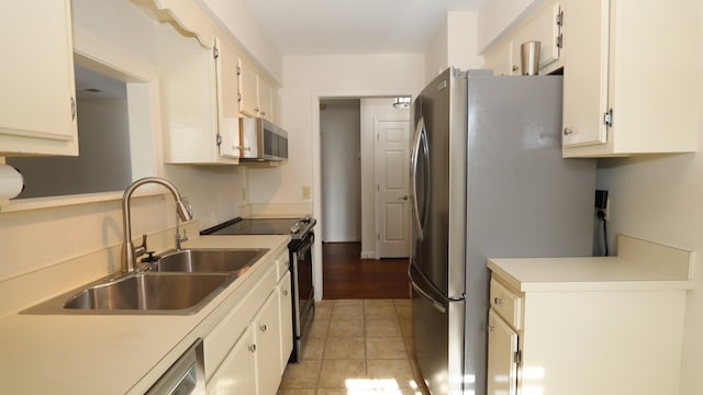 kitchen featuring a sink, stainless steel appliances, light tile patterned flooring, and light countertops