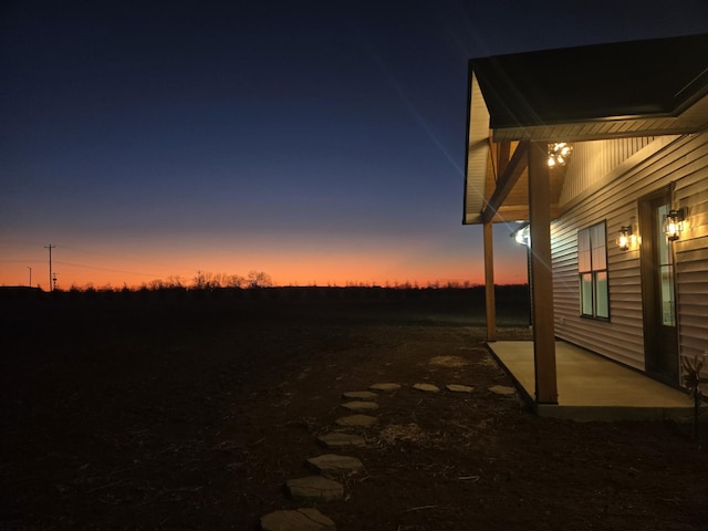 yard at dusk featuring a patio area