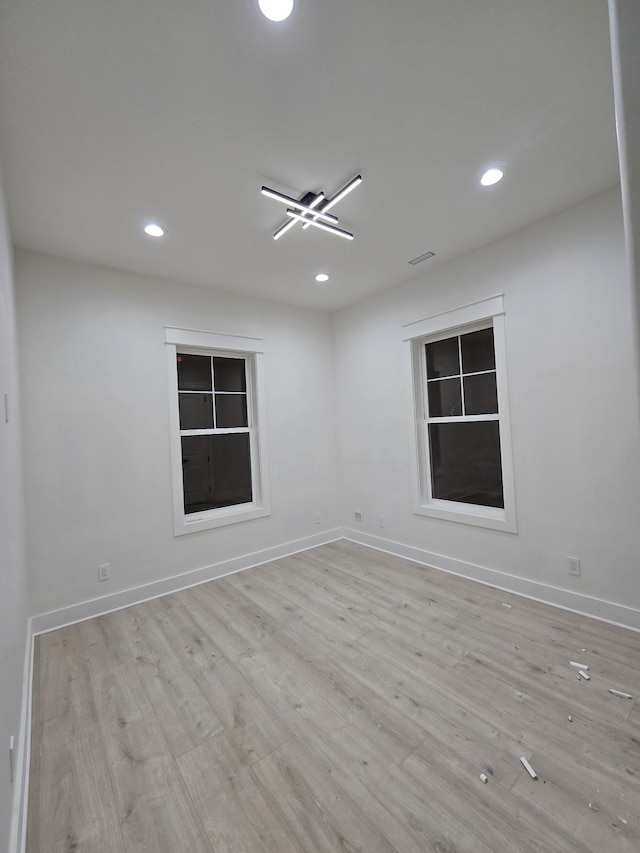 unfurnished room with light wood-style flooring, baseboards, and recessed lighting