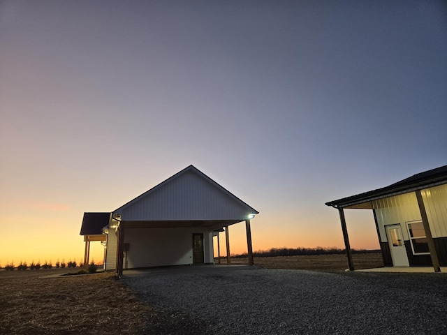 exterior space featuring an attached carport and gravel driveway