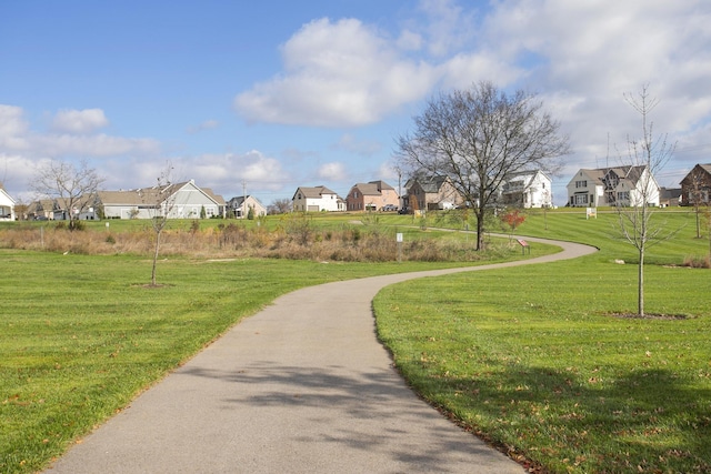 view of property's community with a residential view and a lawn