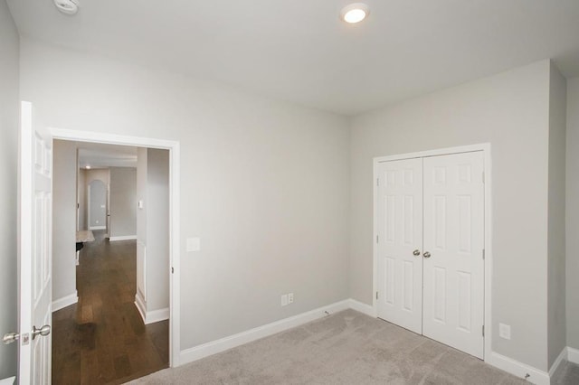 unfurnished bedroom featuring a closet, carpet flooring, and baseboards