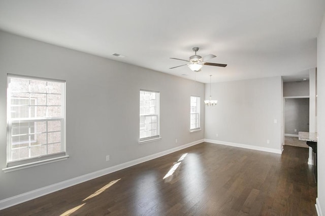 unfurnished room featuring dark wood-style floors, baseboards, and ceiling fan with notable chandelier