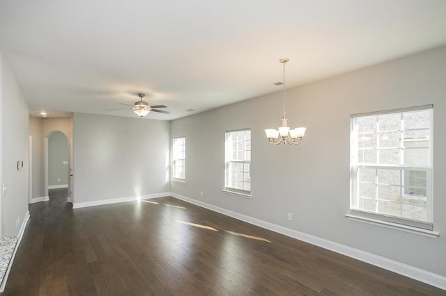 unfurnished room featuring baseboards, arched walkways, dark wood-type flooring, and ceiling fan with notable chandelier