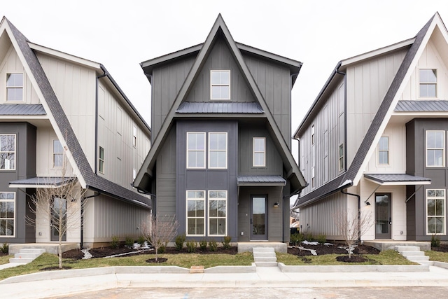 view of front facade with board and batten siding, a standing seam roof, and metal roof