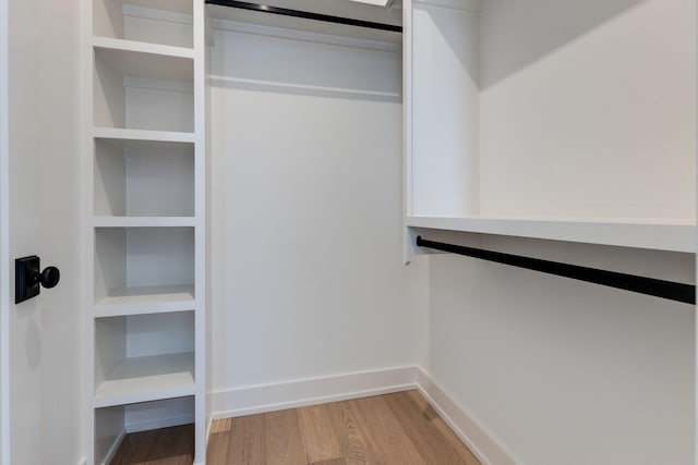 walk in closet with wood finished floors