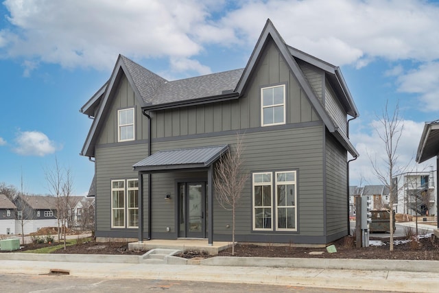 view of front facade featuring board and batten siding, a shingled roof, and central air condition unit