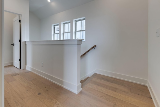 staircase with vaulted ceiling, wood finished floors, and baseboards